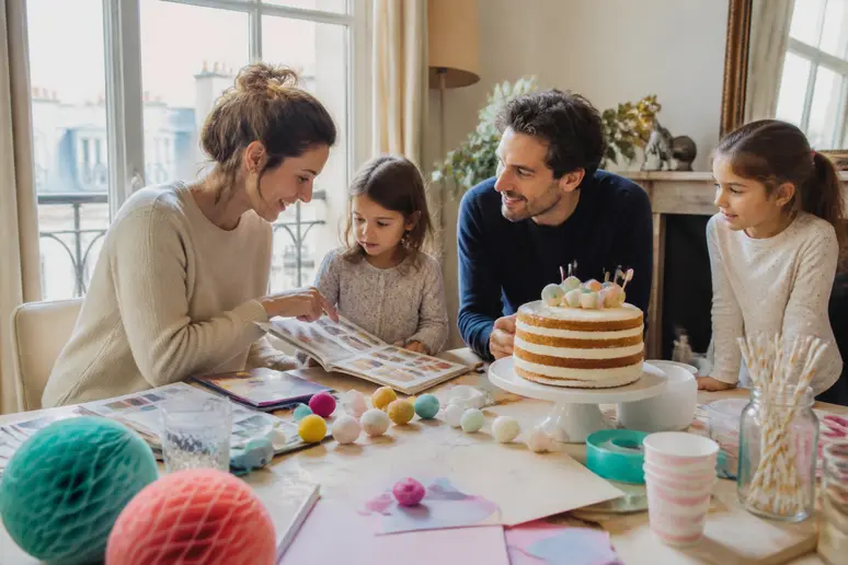 Une famille française discute avec enthousiasme des idées de décoration pour une table d'anniversaire, entourée d'éléments festifs.
