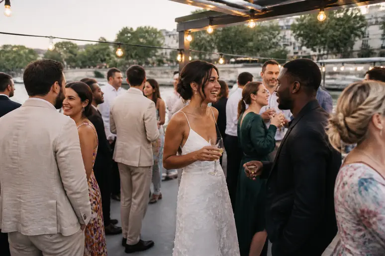 Réception de mariage intime sur la terrasse de la Péniche La Marquise, où des invités profitent de l'ambiance festive en soirée.