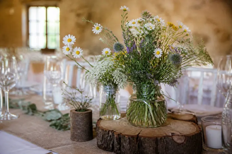 Idée pour mariage thématique champêtre : décoration naturelle avec fleurs sauvages et bois.