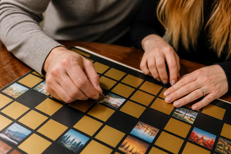 Mains grattant une case d'une affiche interactive pour un cadeau pour un couple sur une table en bois
