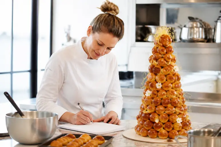 Chef pâtissier notant le nombre de choux nécessaire pour une commande de mariage