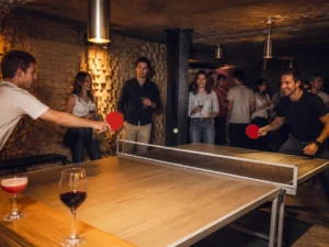 Amis jouant au ping-pong et riant lors d'une soirée privée au Gossima ping pong bar Paris
