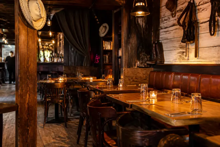 Intérieur d'un bar au décor western avec des tables en bois pour un groupe