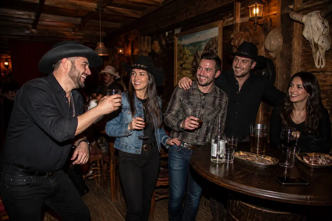 Amis profitant d'une soirée de groupe dans un bar au décor rustique pour un avis saloon far west paris 11