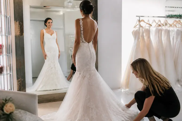 Essayage d'une robe de mariée dans une boutique physique pour valider la coupe