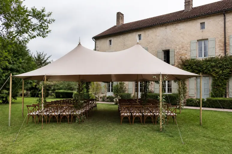 Chapiteau élégant installé dans un jardin français pour une cérémonie laïque, préparé en cas de pluie pour organiser la célébration.