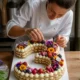 confection artisanale et decoration minutieuse d un number cake aux fruits frais pour un anniversaire