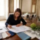 Une wedding planner prépare l'organisation un séminaire avec des échantillons de décoration sur une grande table lumineuse