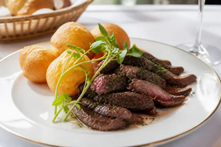 Plat généreux de bœuf et pommes soufflées, spécialité du restaurant Laurent à Paris.