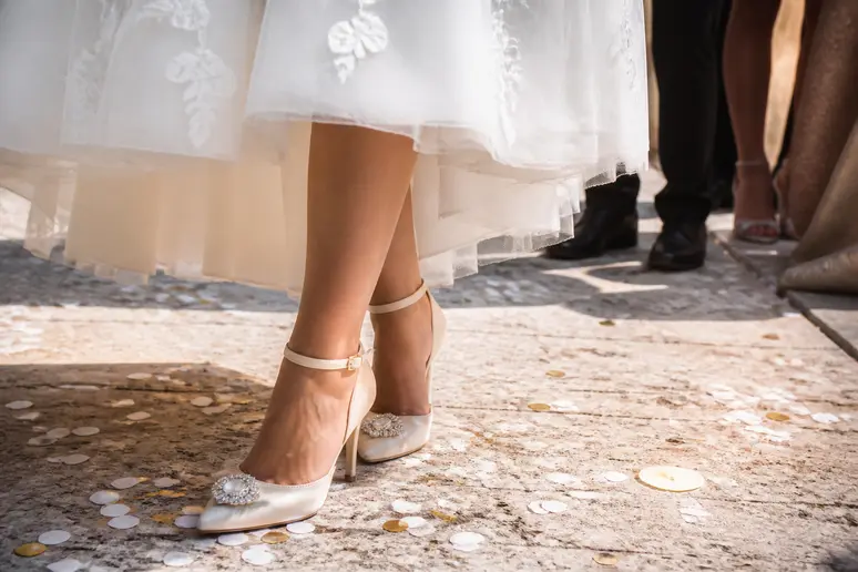 Chaussures de mariage élégantes visibles sous l'ourlet d'une robe de mariée courte pour une cérémonie civile