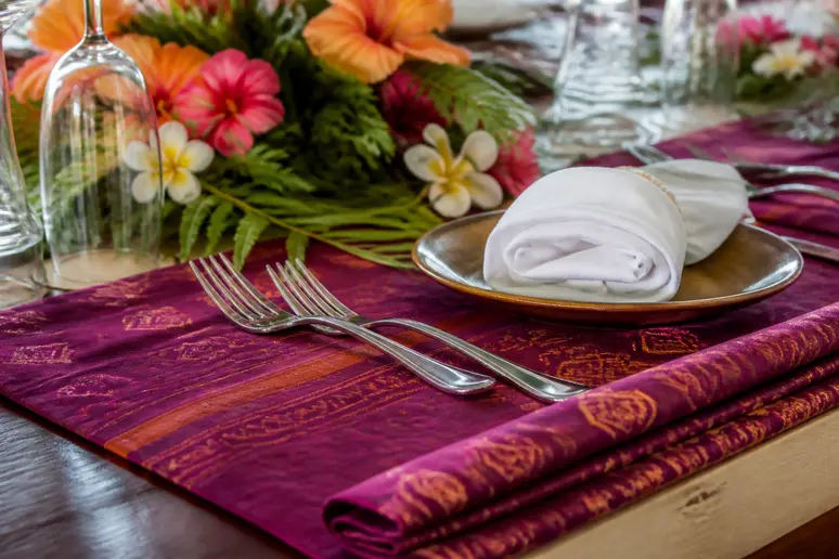 Décoration de mariage avec un sarong coloré utilisé comme chemin de table élégant.