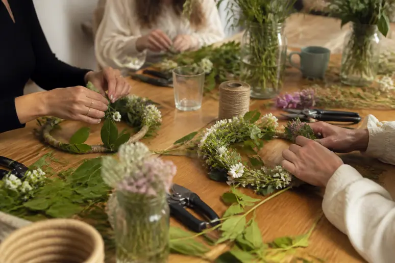 Mains assemblant des végétaux lors d'un atelier créatif pour une activité EVJF tendance.
