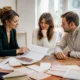 Un couple et un wedding planner étudient un devis papier pour savoir combien coûte un mariage à Chartres