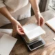 Mains pesant un faire-part sur une balance pour savoir comment choisir enveloppe mariage sans dépasser vingt grammes