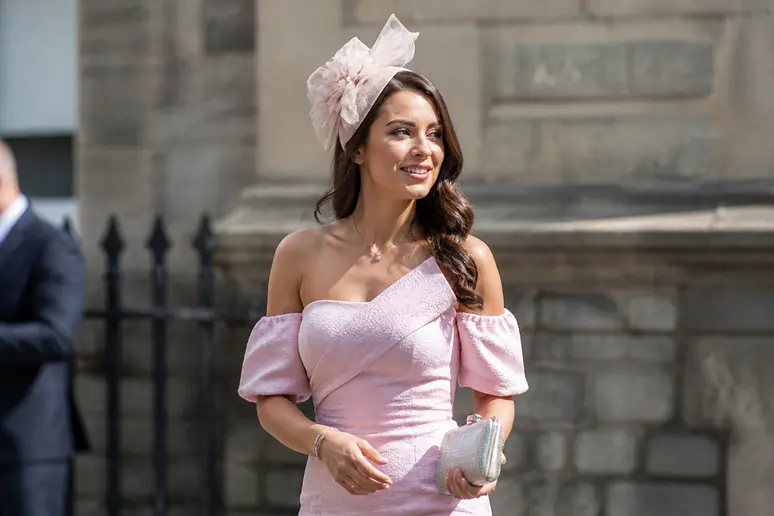 Invitée élégante portant une robe pastel pour respecter les codes d'une tenue de mariage