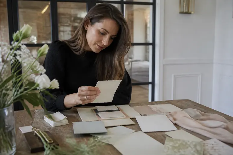 Femme consultant un faire-part pour accorder sa tenue de mariage au thème de la réception