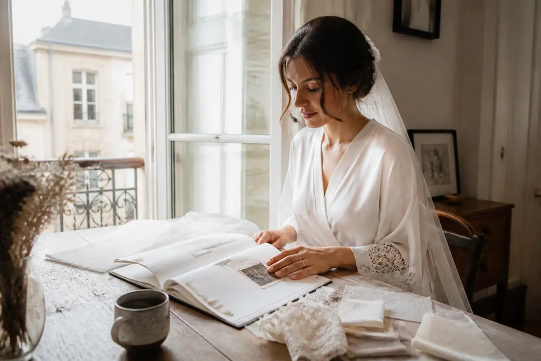 Une future mariee feuillette un livre preparation mariage sur une table en bois lumineux a Chartres