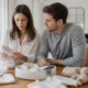 Un couple organise ses essentiels sur une table en bois pour savoir quoi mettre liste naissance efficacement.