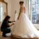 Retouches d'une magnifique robe princesse mariage en tulle dans un atelier lumineux