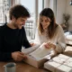 Un jeune couple ouvre un joli cadeau 1 an de mariage en coton dans son salon lumineux.