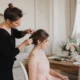 Un coiffeur demoiselle d'honneur prépare la mise en beauté d'une participante avant la cérémonie de mariage.