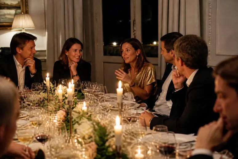 Invités attablés profitant d'un moment calme lors d'une soirée d'anniversaire entre adultes.