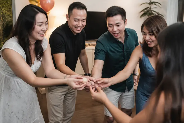 Groupe d'adultes participant à un jeu coopératif d'adresse pour animer la soirée.