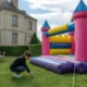 Installation d'un grand château gonflable sur une pelouse pour des tarifs location château gonflable