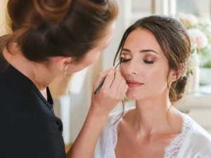 maquillage mariage yeux marrons appliqué avec délicatesse par une professionnelle dans un salon lumineux