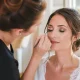 maquillage mariage yeux marrons appliqué avec délicatesse par une professionnelle dans un salon lumineux