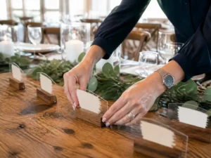 Trois modèles de marque place anniversaire en papier, bois et plexiglas disposés sur une table de fête.