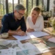 Un couple préparant une célébration avec des documents sur une table pour savoir comment organiser noce d'argent
