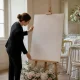 Un panneau bienvenue mariage au format A1 installé sur un chevalet en bois dans une salle de réception lumineuse.