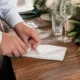Mains en train de réaliser un pliage serviette en papier pour une table de mariage à Chartres
