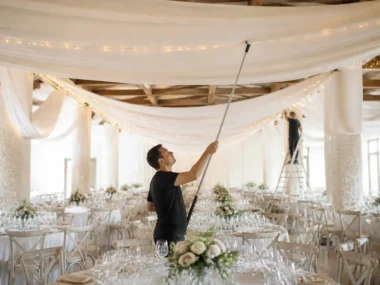 professionnel installant des tentures ignifugées dans une salle de mariage decoration lumineuse à Chartres