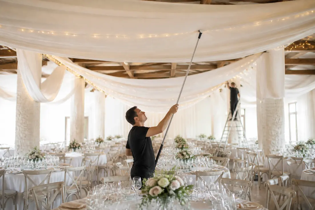 professionnel installant des tentures ignifugées dans une salle de mariage decoration lumineuse à Chartres